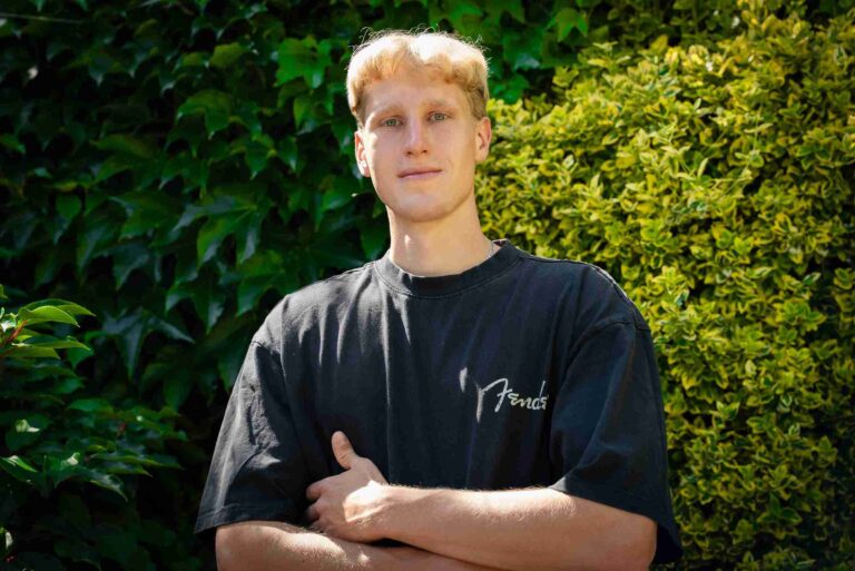 Fotograf na tle zieleni – ujęcie portretowe w naturalnym świetle